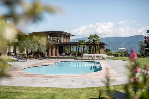 阿皮亚诺苏拉斯特拉达隆格霍夫阿西兹酒店的一座带房子的庭院内的游泳池