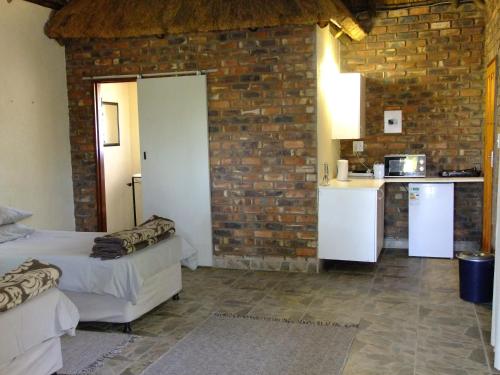 Mkolo Hunting and Wildlife的厨房配有两张床和砖墙