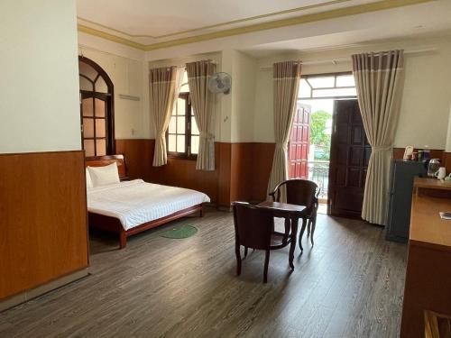 永隆Khách sạn Mekong Star的卧室配有一张床和一张桌子及椅子