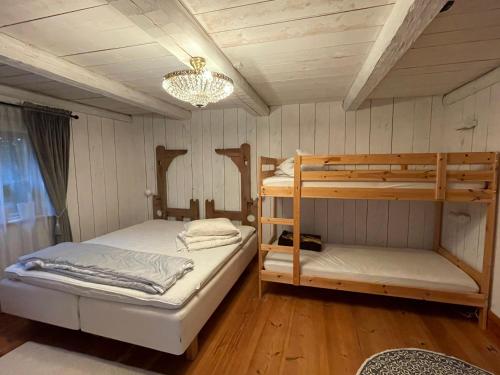 雷克桑德Dalastuga med tillgång till badplats的一间卧室设有两张双层床和吊灯。