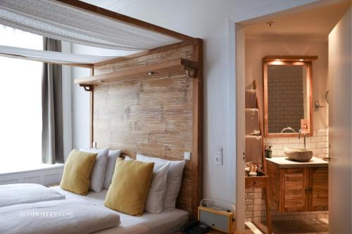 哥本哈根阿科斯尔古尔德斯梅登酒店的一间卧室配有一张带木制床头板的床