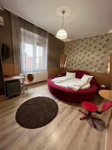 马泰绍尔考Korona Panzió的一间卧室,卧室内设有一张红色的大床