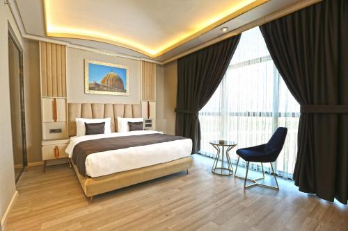 马尔丁ANEMON MARDIN OTEL的酒店客房设有一张床和一个大窗户