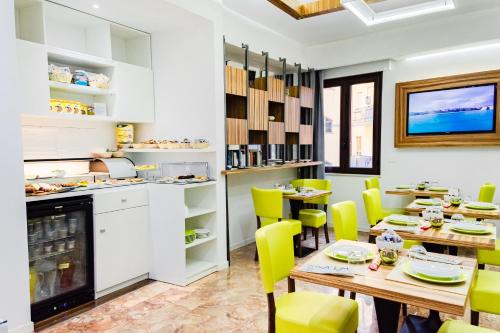特罗佩阿名利场住宿加早餐旅馆的用餐室配有桌子和黄色椅子