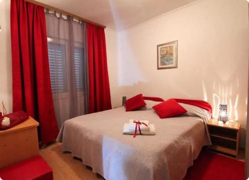 洛帕德Apartment Lopud 17200a的卧室配有红色窗帘的床