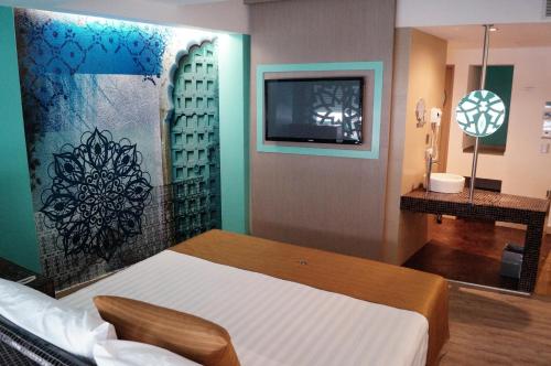 墨西哥城阿玛拉酒店的一间卧室配有一张床,墙上配有电视