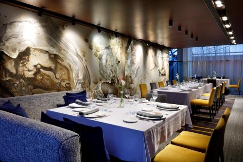 略夫雷加特河畔奥斯皮塔莱特Hesperia Fira的用餐室配有白色的桌子和黄色的椅子