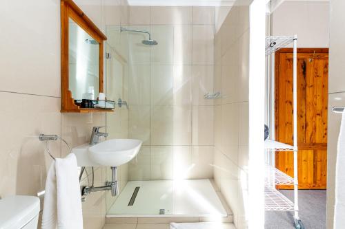 兰格班Adventure Pad's by The Farmhouse Hotel的白色的浴室设有水槽和淋浴。