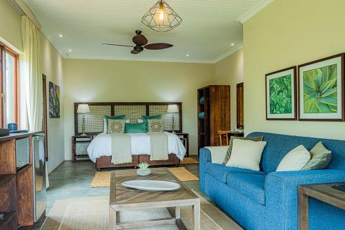 希尔顿Hilton Bush Lodge & Function Venue的客厅配有蓝色的沙发和床。