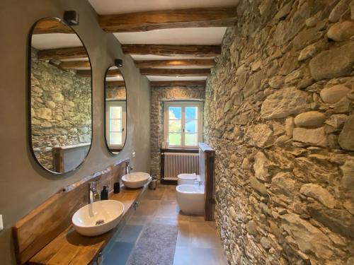 瓦拉洛Mountain Cabin Valsesia Appartement Stella的一间带两个水槽和石墙的浴室