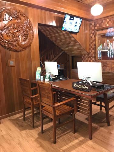 库塔海居巴厘岛美景沙滩酒店的一张桌子,里面配有两个显示器和椅子
