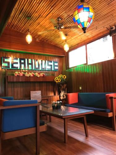 库塔海居巴厘岛美景沙滩酒店的餐厅设有一张桌子和蓝色的椅子,并有一个健康标志