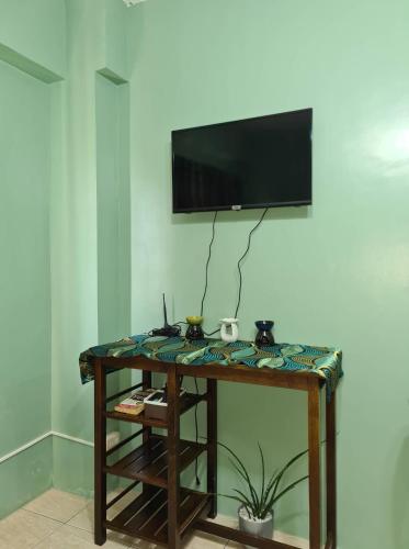 CaintaBudget Friendly Staycation in Valley Golf的一间房间,墙上设有一张桌子和一台电视