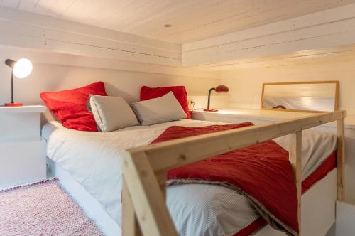列日Le Loft Nautilus by Maison Brasseurs d'Etoiles的一间卧室配有红色和白色枕头的床