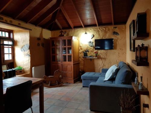 伊科德洛斯维诺斯Finca Los Ciruelos Casas Rurales的客厅配有蓝色的沙发和桌子