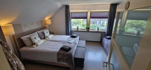 雷斯Bed & Breakfast Ravelin的一间卧室设有一张床和两个窗户。
