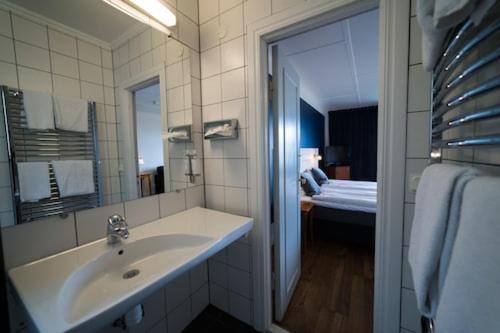 格兰纳吉尔内奥特内酒店的一间带水槽和镜子的浴室以及一张床