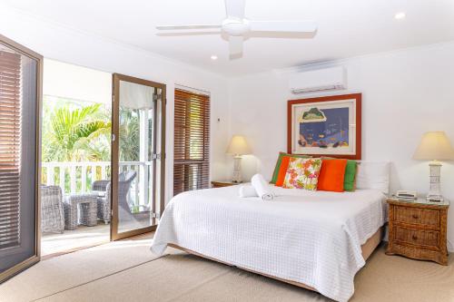 努萨维尔海滩度假酒店的一间白色卧室,配有床和阳台