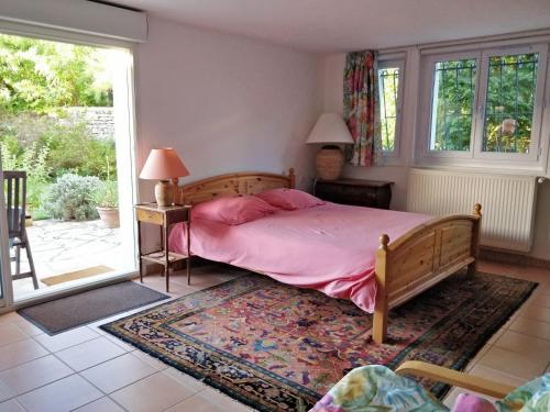 安格雷T1 ou T2 dans villa avec jardin proche Biarritz的一间卧室配有一张带粉色床单的床和一扇窗户。