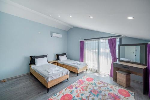 费特希耶Villa Ada的一间卧室配有两张床和一台平面电视