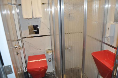 伊斯帕尔KOÇ OTEL ELİT TERMİNAL的一间带红色卫生间和淋浴的浴室