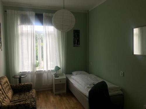 瓦根Hunnebergs Gård Hostel & Camping的卧室配有床、椅子和窗户。
