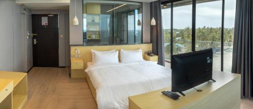芭环礁Clarks Exotica, Kamadhoo Maldives的一间卧室配有一张床和一台电视。
