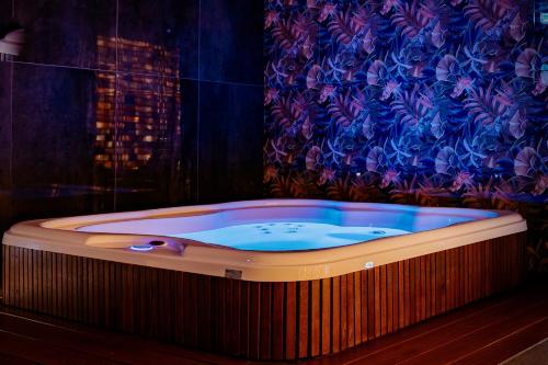 华沙Jess Hotel & Spa Warsaw Old Town的一个带窗帘的客房内的按摩浴缸