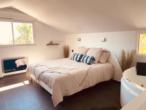 圣马克西姆Villa Jungle Beach的一间卧室配有一张床和一个浴缸,还有一个壁炉