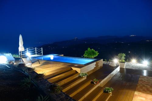 切法卢Villa Magliolo的享有游泳池的夜景,设有楼梯和灯光