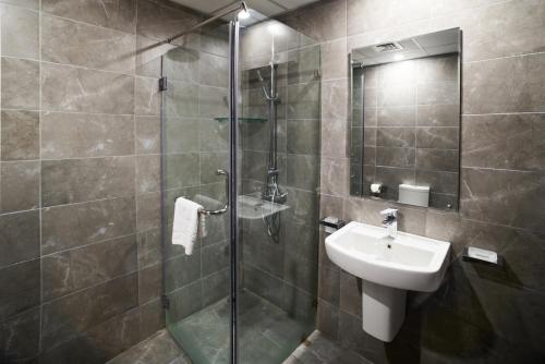 麦纳麦Vita Tower的带淋浴、水槽和玻璃淋浴间的浴室