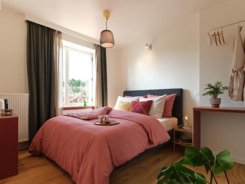 布鲁日Rûte - Bed no Breakfast的一间卧室配有一张带红色毯子的床和窗户。