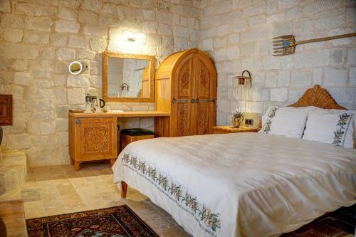 内夫谢希尔Aşk-ı Nare Cave Hotel Swimming Pool Hot & SPA的一间卧室配有一张床、一个梳妆台和镜子