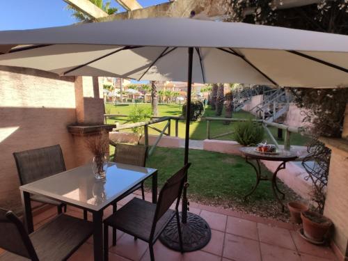 伊斯兰蒂拉Beach-Golf House的庭院内桌椅和遮阳伞
