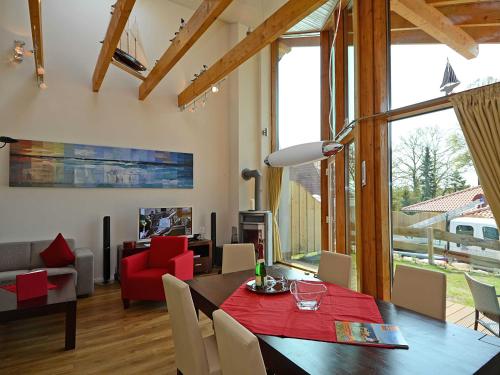 奥斯赛拜-塞林Ferienhaus Luv & Lee - Apt. 01的一间带红色桌子的用餐室和一间客厅