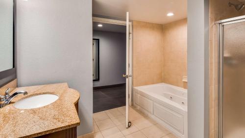 尚佩恩温盖特温德姆香槟旅馆的浴室配有水槽、淋浴和浴缸。