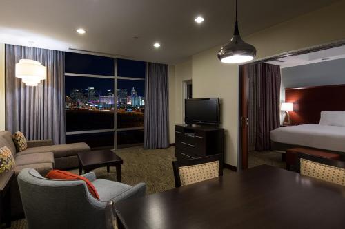 拉斯维加斯Staybridge Suites Las Vegas - Stadium District的酒店客房,配有一张床铺和一张桌子,还有一间客房