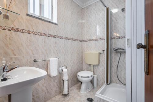 纳扎雷Carepa SUITES的浴室配有卫生间、盥洗盆和淋浴。
