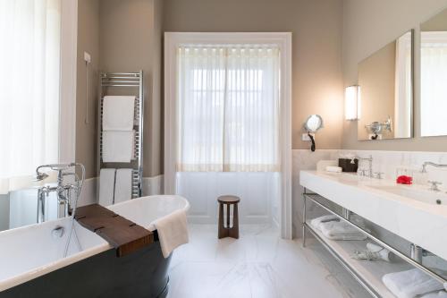 丰沙尔Casa Velha do Palheiro Relais & Chateaux的白色的浴室设有浴缸和水槽。