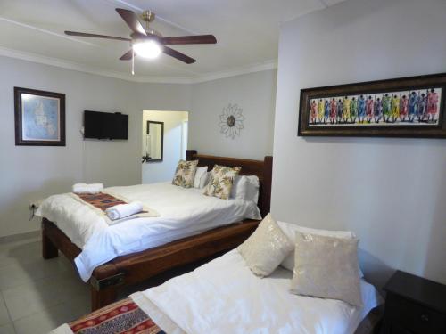 楚梅布Tsumeb Backpackers & Safari的一间卧室配有两张床和吊扇