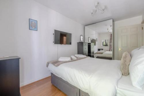 伦敦Bright 1 Bedroom Flat in Kensington Olympia的卧室配有一张白色大床和镜子