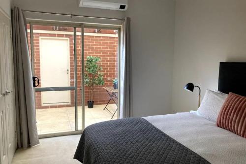 珀斯Modern 2 Bedroom Apartment in Perth的一间卧室设有一张床和一个滑动玻璃门