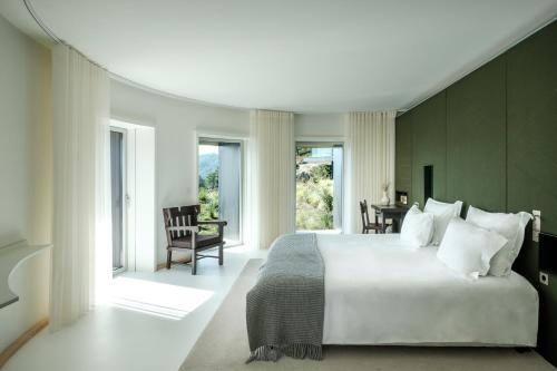 曼泰加什Casa de São Lourenço - Burel Mountain Hotels的一间卧室配有一张大床和一张桌子及椅子