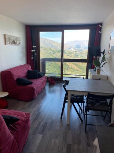 勒克比尔Studio au pied des pistes 4 pers, Alpes Le Corbier的客厅配有红色的沙发和桌子
