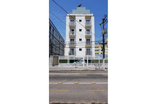 瓜鲁雅Apartamentos Enseada Guaruja的白色建筑前的一条空的街道