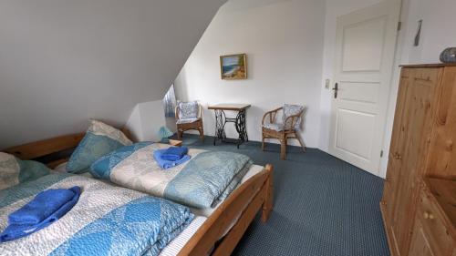 PutgartenFerienhaus Arkona Putgarten的一间卧室配有两张带蓝色床单和椅子的床