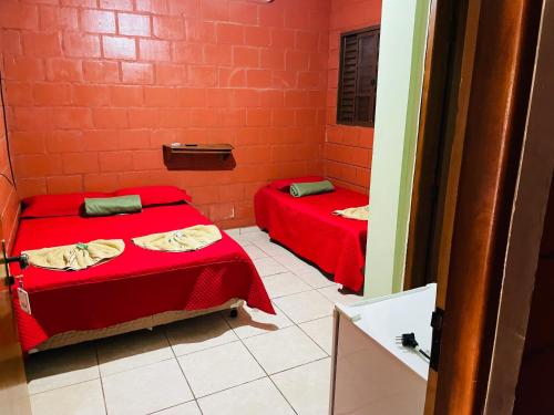 特雷斯拉瓜斯Hotel Solaris的配有红色墙壁的小客房内的两张床