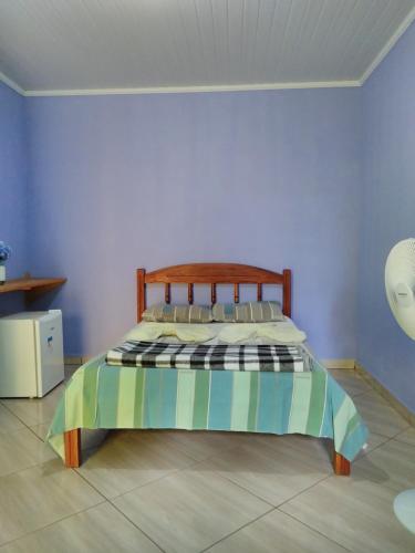 韦尔卡鲍Pousada Abacateiro的一间卧室配有一张带木制床头板的床
