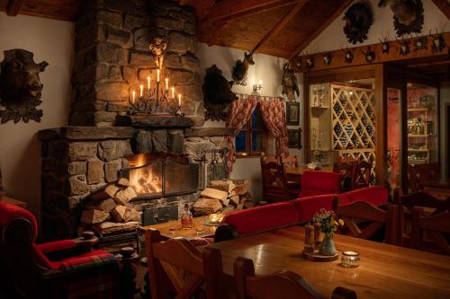 耶塞尼克十字山酒店的餐厅设有石制壁炉、桌子和椅子