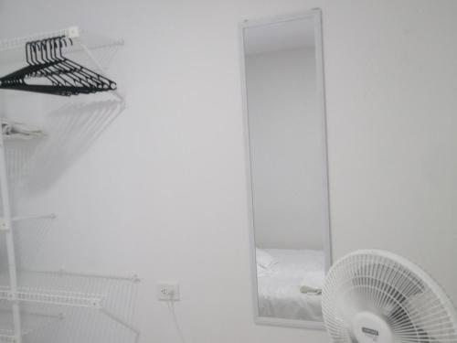卡塔赫纳Hermoso Apartaestudio, privado, acogedor, super aseado, excelente ubicación!的白色的客房配有镜子和风扇